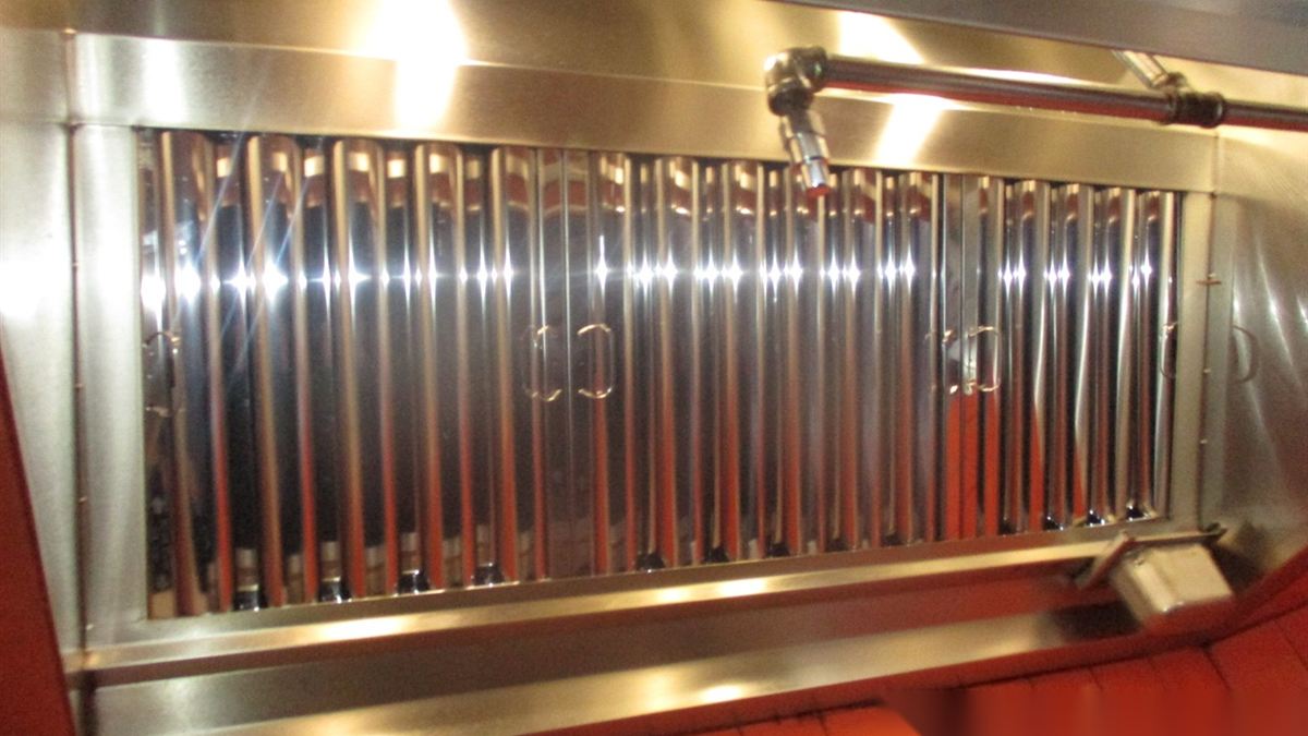 Restaurant kitchen hood with fire suppression nozzle